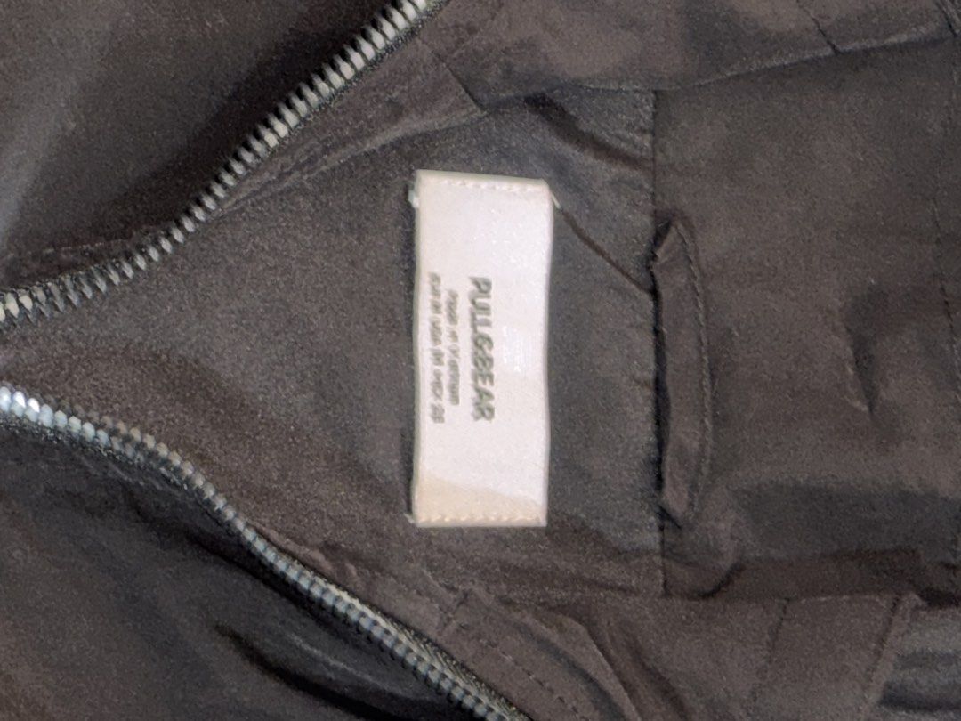 Bershka Black Hooded Zip-Up Jacket (Category: Coats, Jackets and Outerwear) located in Manila. Submitted by bellsellsss (Listing ID 1442546748, Image 2). Description: - Black hooded jacket from Pull & Bear - Zip-up front - Two buttoned pockets - Drawstring hem - Estimated size M - Ideal for layering or cooler weather.