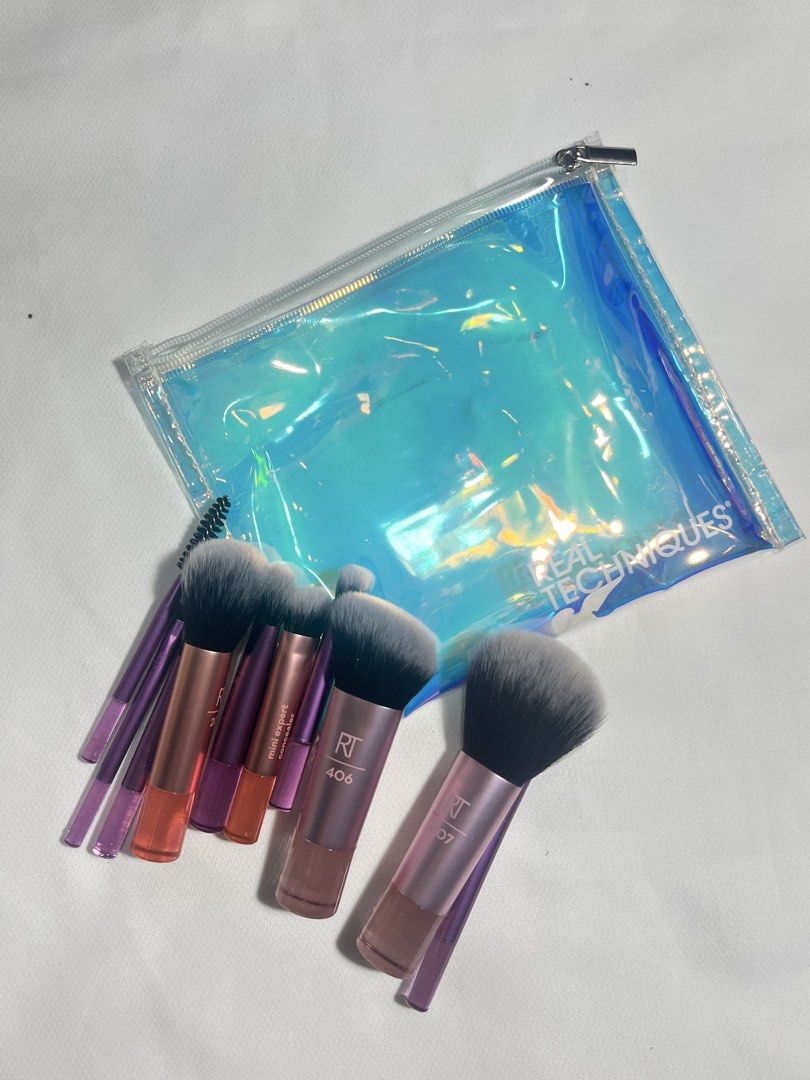 Real Techniques Makeup Brush Set with Pouch (Category: Makeup) located in Manila. Submitted by itskylieeee_ (Listing ID 1442579098, Image 3). Description: - Real Techniques makeup brush set - Includes multiple brushes for various makeup applications - Comes with a stylish holographic pouch for storage - Features purple handles and soft synthetic bristles - Ideal for everyday makeup routines or travel essentials.