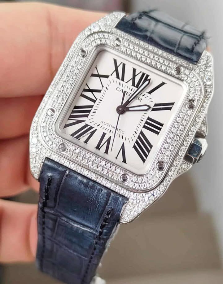 SANTOS 100 MEDIUM DIAMOND BEZEL ✨ (Category: Luxury Watches) located in Manila. Submitted by kristinepenafiel (Listing ID 1442648912, Image 1). Description: SANTOS 100 MEDIUM DIAMOND BEZEL ✨ ₱288,000 Complete Set Includes Extra Pink Cartier Leather Strap Customized Diamond Bezel Model: W20126X8 Automatic Movement Case Size: 33mm × 43mm White Dial Condition: 9/10 A stylish and iconic Cartier Santos 100 Medium featuring a custom diamond bezel that 