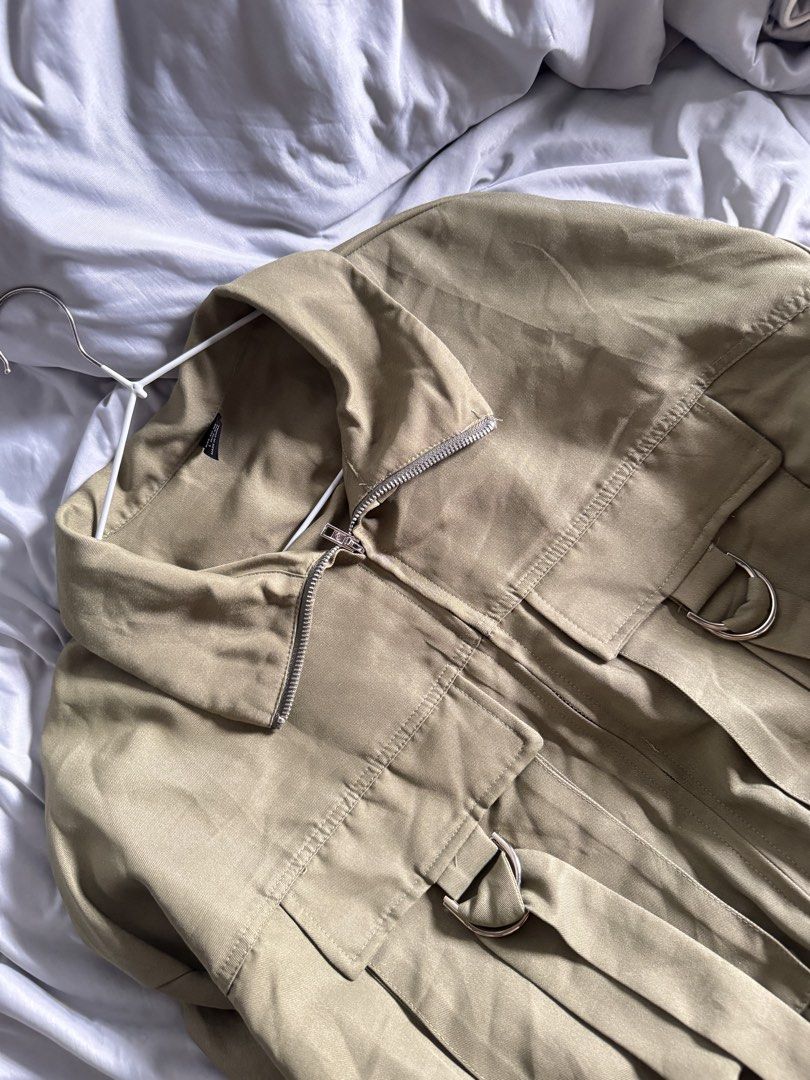 Shein Khaki Utility Jacket with D-ring Details (Category: Coats, Jackets and Outerwear) located in Las Pinas. Submitted by preiscloset (Listing ID 1442575254, Image 3). Description: - Khaki utility jacket from Shein - Size: L - Zip-up front with collar - Two chest pockets with D-ring strap details - Balloon sleeves with elasticated cuffs - Elasticated hem - Ideal for casual streetwear style.