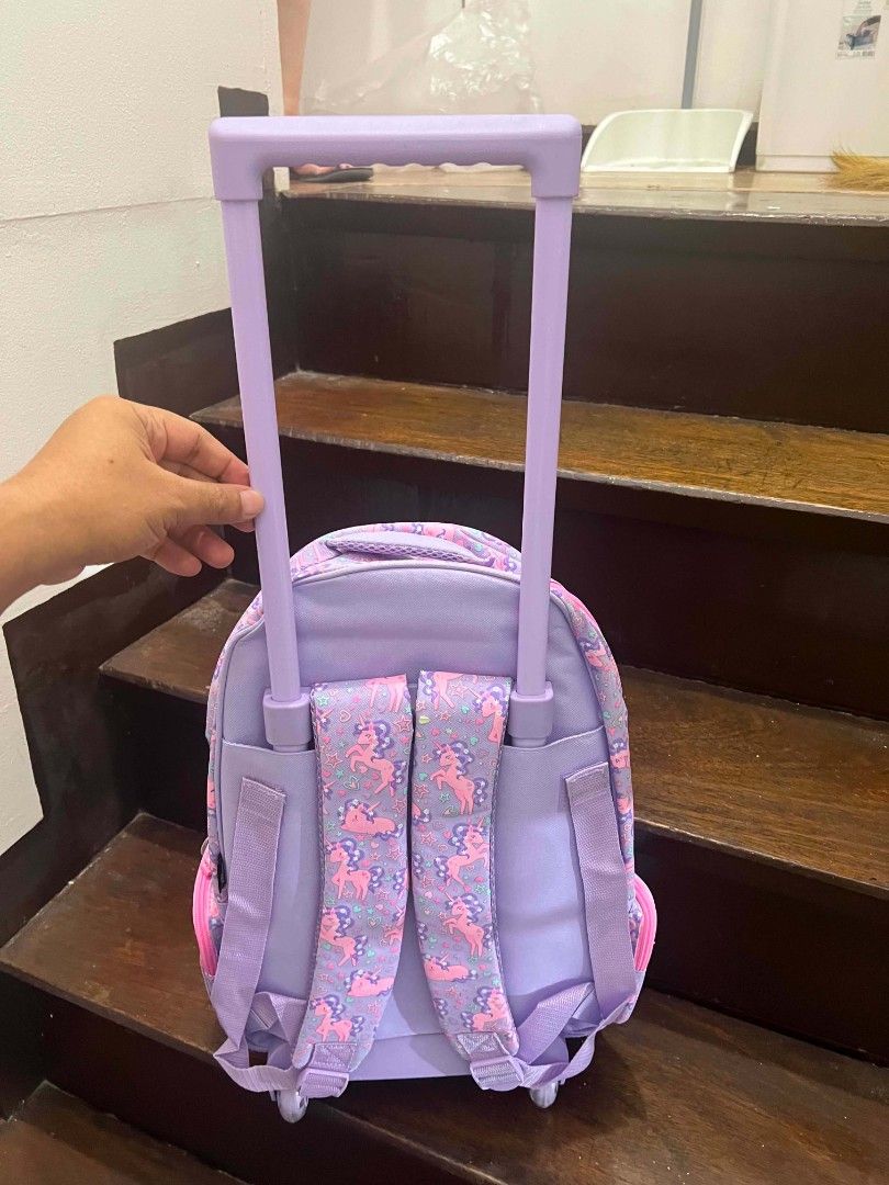 Smiggle Unicorn Rolling Backpack Purple Pink Wheels (Category: Babies & Kids Fashion) located in Quezon City. Submitted by miro_shoppaloco (Listing ID 1442651613, Image 2). Description: - Adorable Smiggle rolling backpack with a fun unicorn design. - Features a vibrant purple and pink color scheme - Equipped with wheels and a retractable handle for effortless carrying. - Includes padded shoulder straps for extra comfort. - Perfect for school days