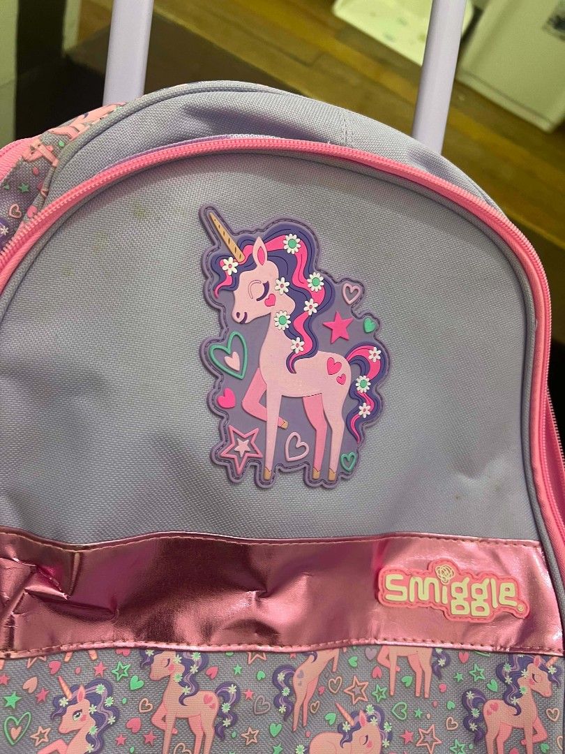 Smiggle Unicorn Rolling Backpack Purple Pink Wheels (Category: Babies & Kids Fashion) located in Quezon City. Submitted by miro_shoppaloco (Listing ID 1442651613, Image 1). Description: - Adorable Smiggle rolling backpack with a fun unicorn design. - Features a vibrant purple and pink color scheme - Equipped with wheels and a retractable handle for effortless carrying. - Includes padded shoulder straps for extra comfort. - Perfect for school days