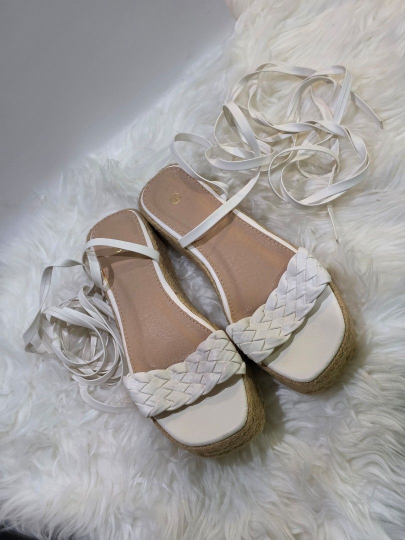 White Espadrille Platform Sandals with Tie-Up Straps (Category: Flats & Sandals) located in Mandaluyong City. Submitted by hellokrissel (Listing ID 1442708211, Image 1). Description: - Chic white espadrille platform sandals - Features a stylish braided strap across the toes - Long tie-up straps for a secure and adjustable ankle wrap - Textured sole provides excellent grip - Ideal for completing your summer outfits.