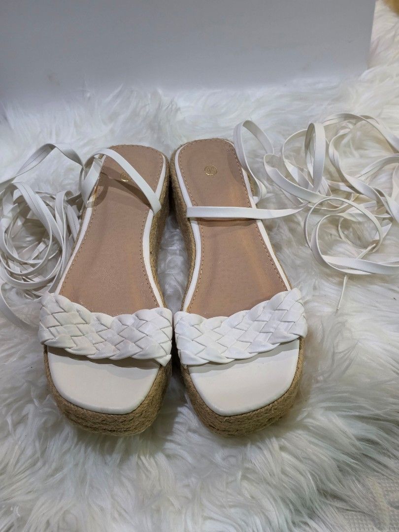 White Espadrille Platform Sandals with Tie-Up Straps (Category: Flats & Sandals) located in Mandaluyong City. Submitted by hellokrissel (Listing ID 1442708211, Image 2). Description: - Chic white espadrille platform sandals - Features a stylish braided strap across the toes - Long tie-up straps for a secure and adjustable ankle wrap - Textured sole provides excellent grip - Ideal for completing your summer outfits.