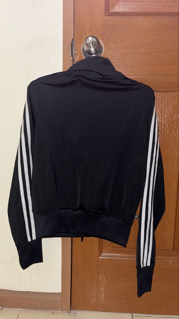 Adidas Black Track Jacket with White Stripes (Category: Coats, Jackets and Outerwear) located in Quezon City. Submitted by declutteringsquirrel (Listing ID 1442846131, Image 2). Description: - Classic Adidas track jacket - Color: Black with iconic white 3-stripes on sleeves - Features: Full zip closure, ribbed cuffs and hem - Versatile: Great for casual wear or sports - Sustainable: Made with recycled polyester.