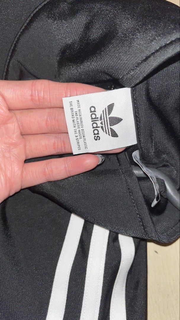 Adidas Black Track Jacket with White Stripes (Category: Coats, Jackets and Outerwear) located in Quezon City. Submitted by declutteringsquirrel (Listing ID 1442846131, Image 3). Description: - Classic Adidas track jacket - Color: Black with iconic white 3-stripes on sleeves - Features: Full zip closure, ribbed cuffs and hem - Versatile: Great for casual wear or sports - Sustainable: Made with recycled polyester.