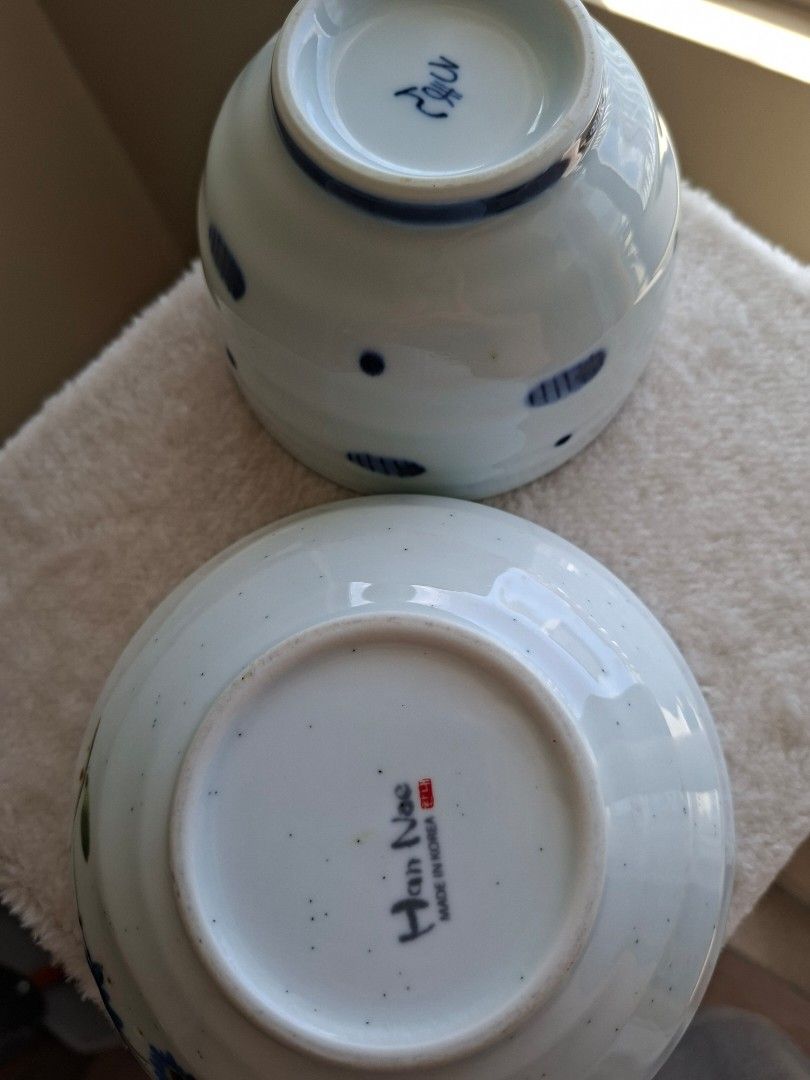 Ceramic Bowls - Blue Floral & Dots (Category: Dinnerware & Cutlery) located in Taguig. Submitted by kitssale (Listing ID 1442749269, Image 3). Description: - Set of 2 unique ceramic bowls - One bowl: blue flowers and green leaves design - Second bowl: blue dots design - Both bowls are white with speckles inside - Larger bowl marked 'Han Nae made in Korea' - Ideal for serving food or as decorative pieces.