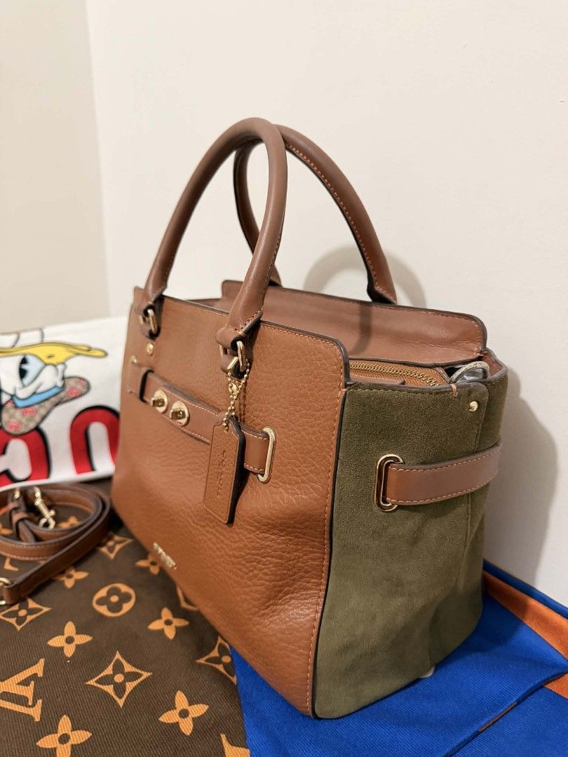 Coach Brown Leather & Olive Suede Satchel Bag (Category: Activewear) located in Manila. Submitted by welloved.325 (Listing ID 1442912237, Image 3). Description: - Authentic Coach satchel bag - Rich brown pebbled leather with olive green suede accents - Elegant gold hardware details - Comfortable top handles - Includes a detachable crossbody strap for versatile wear - Spacious interior with a zip pocket and slip pockets - Interior is clean and wel