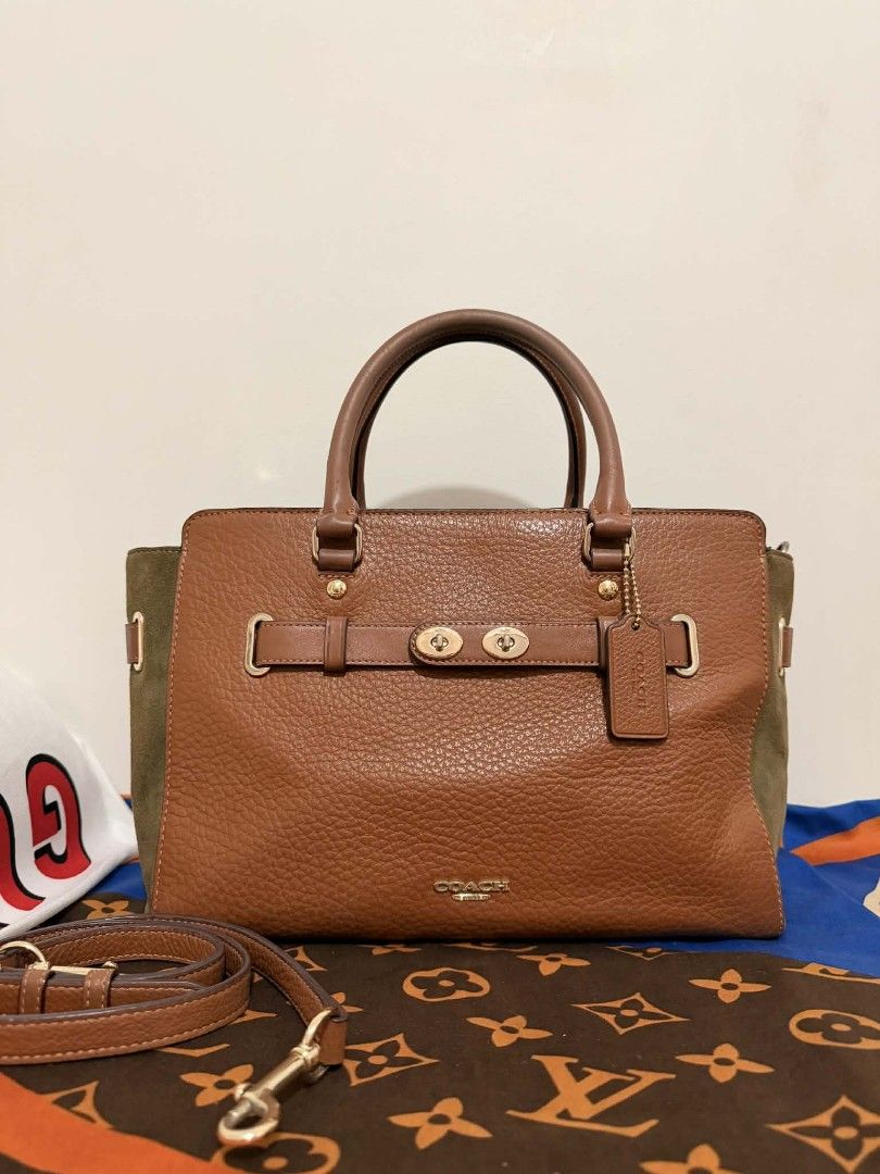 Coach Brown Leather & Olive Suede Satchel Bag (Category: Activewear) located in Manila. Submitted by welloved.325 (Listing ID 1442912237, Image 1). Description: - Authentic Coach satchel bag - Rich brown pebbled leather with olive green suede accents - Elegant gold hardware details - Comfortable top handles - Includes a detachable crossbody strap for versatile wear - Spacious interior with a zip pocket and slip pockets - Interior is clean and wel