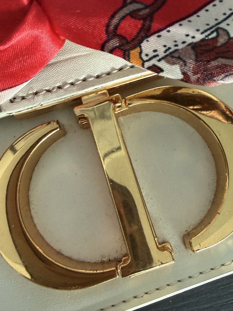 Dior White Leather Shoulder Bag with Gold CD Clasp (Category: Luxury Bags & Wallets) located in Mandaluyong City. Submitted by mamasamshops (Listing ID 1442770568, Image 2). Description: - Authentic white leather Dior shoulder bag - Iconic gold CD clasp closure - Comes with a red and cream patterned silk scarf tied to the strap twilly to cover the claw - Includes original Dior paper bag only .