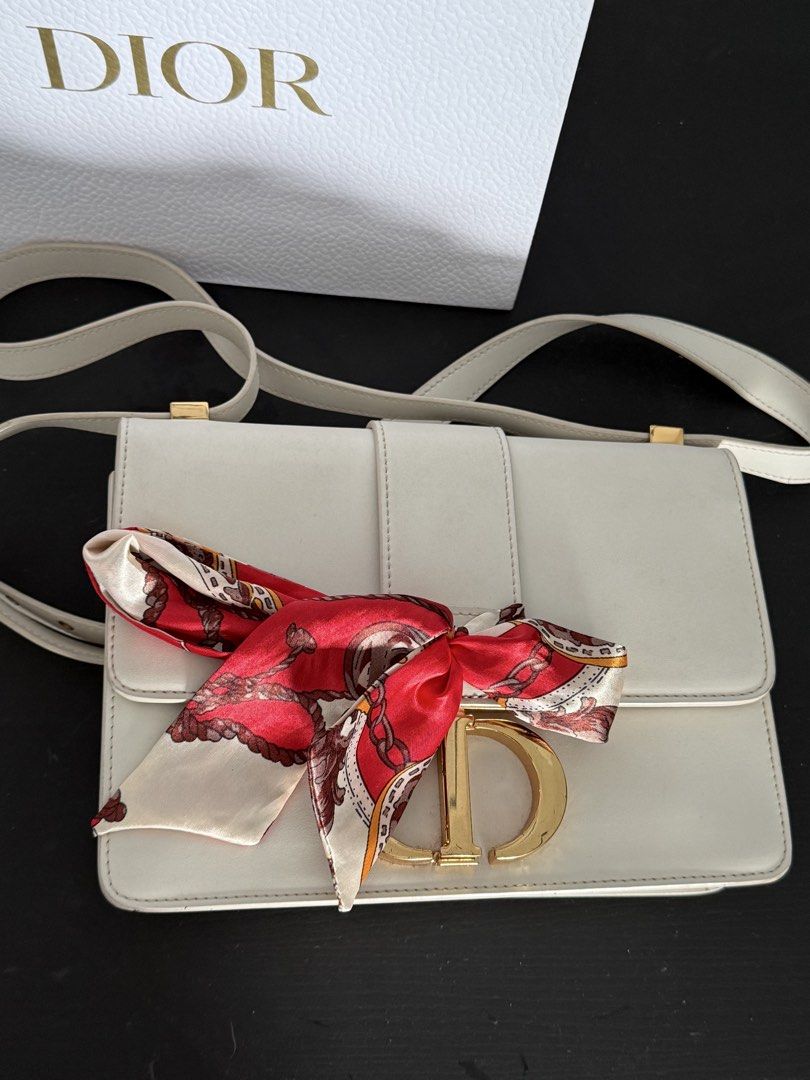 Dior White Leather Shoulder Bag with Gold CD Clasp (Category: Luxury Bags & Wallets) located in Mandaluyong City. Submitted by mamasamshops (Listing ID 1442770568, Image 3). Description: - Authentic white leather Dior shoulder bag - Iconic gold CD clasp closure - Comes with a red and cream patterned silk scarf tied to the strap twilly to cover the claw - Includes original Dior paper bag only .