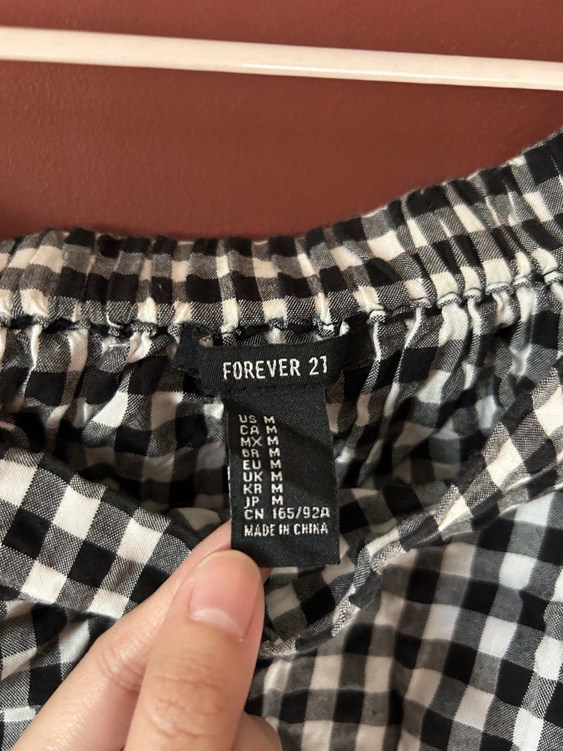 Forever 21 Black and White Gingham Off-Shoulder Tie-Front Top (Category: Blouses) located in Cavite. Submitted by jp________ (Listing ID 1442798846, Image 2). Description: - Cute off-shoulder top from Forever 21 - Black and white gingham pattern - Tie-front detail at the bottom - Elasticated neckline and cuffs - Estimated size: Medium - Ideal for casual outings.