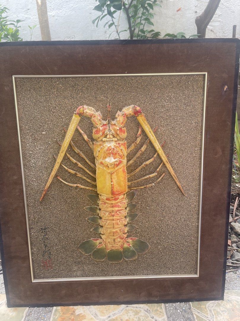 Framed Lobster Wall Art - Unique Seafood Display (Category: Frames & Pictures) located in Manila. Submitted by chesterson1979. (Listing ID 1442737871, Image 1). Description: - Unique framed art piece - Features a realistic lobster - Textured sand-like background - Artist's signature/mark in bottom left corner - Ideal for seafood restaurants or quirky home decor.