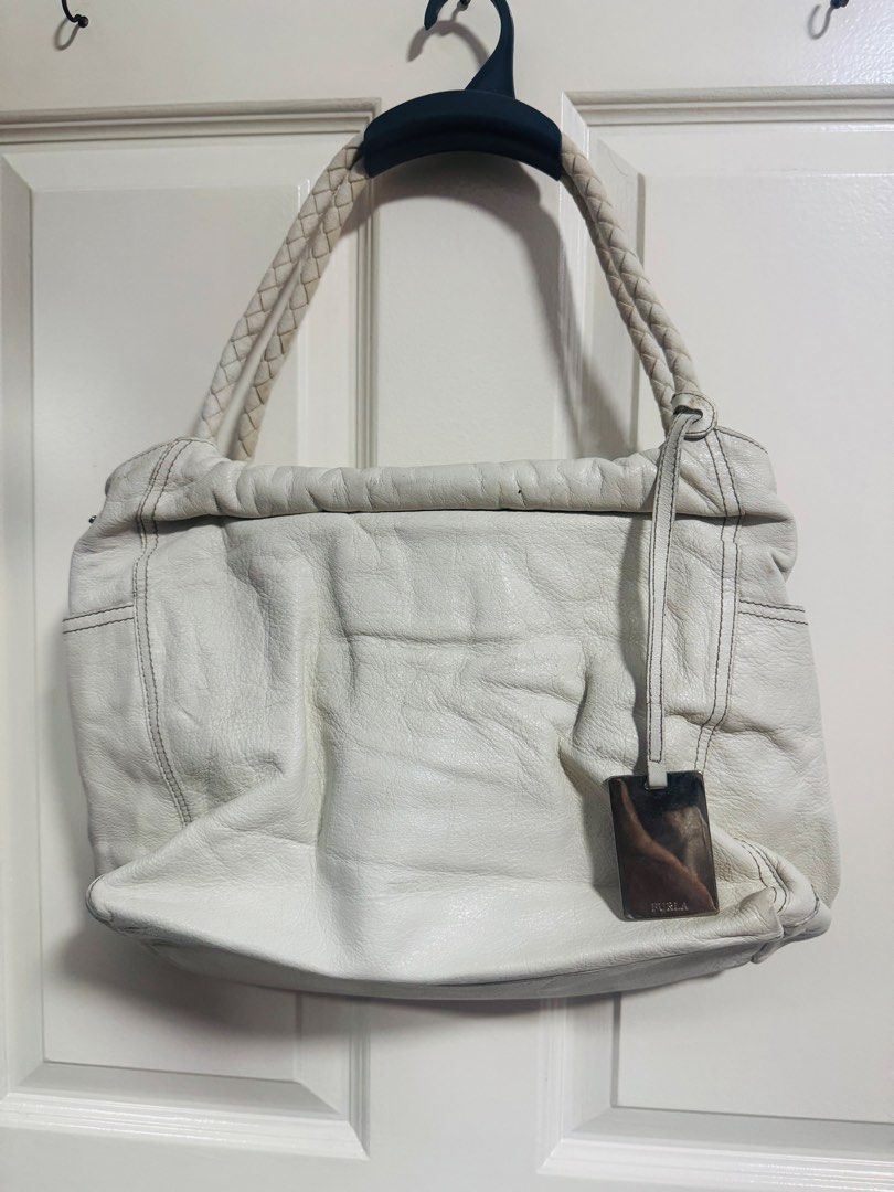 Furla White Leather Braided Handle Shoulder Bag (Category: Luxury Bags & Wallets) located in Quezon City. Submitted by TGDL123 (Listing ID 1442875790, Image 1). Description: - Authentic Furla white leather shoulder bag - Features stylish braided handles - Elegant metal tag with Furla logo - Soft, slouchy leather texture - Ample interior space for essentials - Ideal for everyday wear -Vintage Preloved.