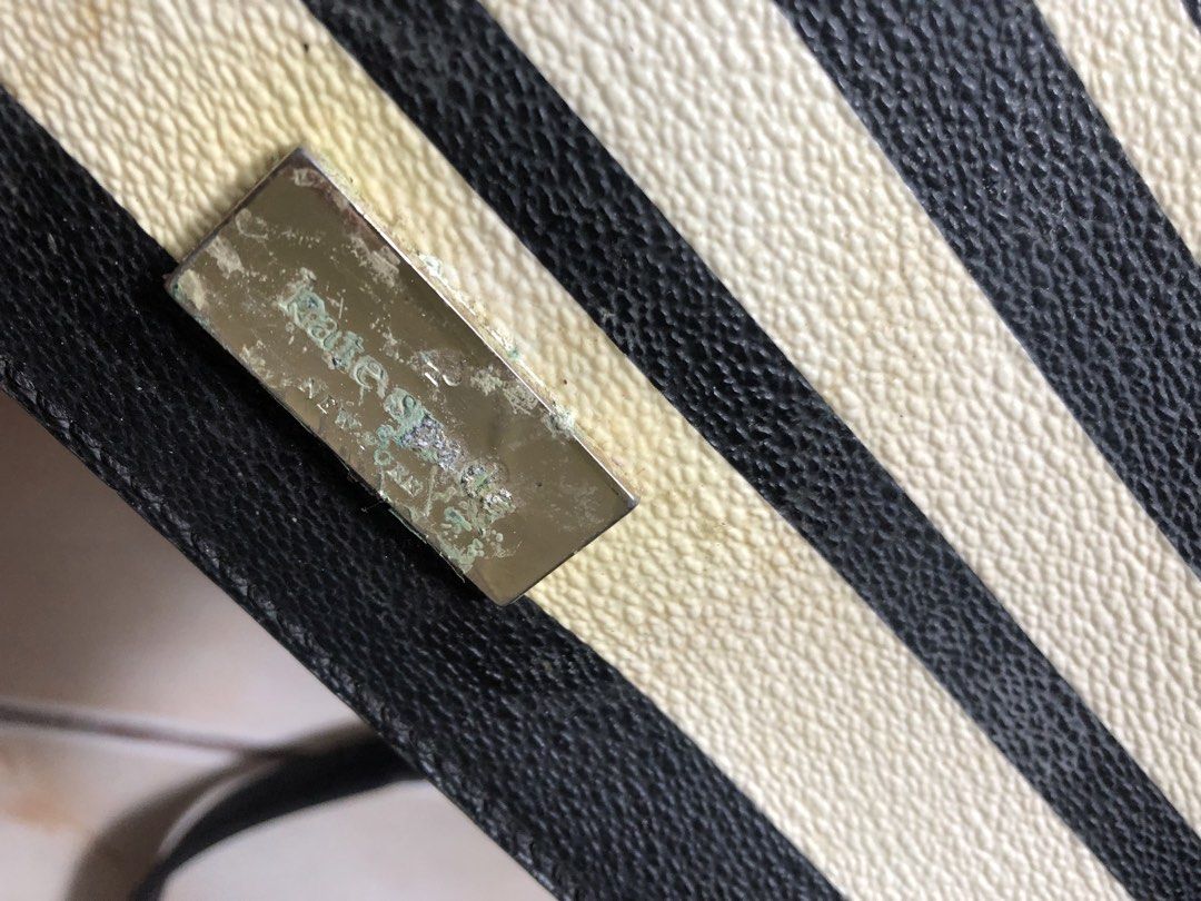 (Kate Spade) Striped Crossbody Bag (Category: Cross-body Bags) located in Mapandan. Submitted by olibski (Listing ID 1442782356, Image 2). Description: Heavily Used, Strap has been detached. - Authentic Kate Spade crossbody bag - Classic black and cream stripe design - Durable leather and PVC material - Interior features signature Kate Spade logo lining - Adjustable strap for comfortable wear - Shows some signs of wear on the metal plate and bag,