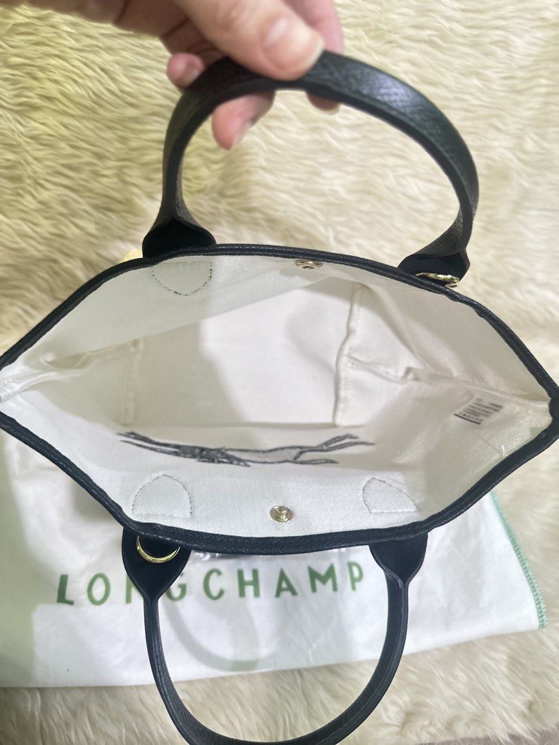 Longchamp Le Pliage Cuir Straw Tote Bag (Category: Luxury Bags & Wallets) located in Angeles City. Submitted by chicprelovedstuffs.owl (Listing ID 1442778476, Image 3). Description: Once used ; RFS: Decluttering Halos mukha pa talaga bago Comes with dustbag This is a Longchamp Le Panier Pliage straw-effect canvas tote bag featuring an embroidered black horse logo and black leather handle - Authentic Longchamp tote bag - Material: Straw with black