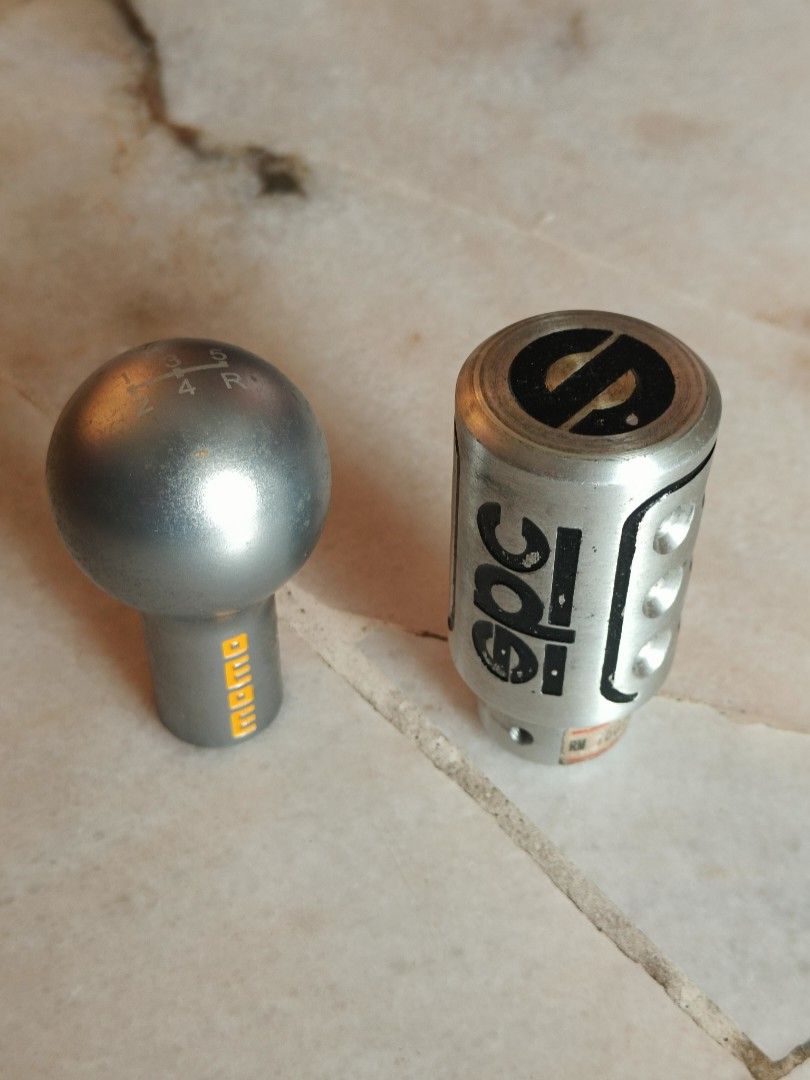 Momo & EPC Silver Gear Knobs (Category: Auto Accessories) located in Subang Jaya. Submitted by therealyos (Listing ID 1442845665, Image 1). Description: - Selling a pair of metal gear knobs: 1 Momo, 1 EPC. - Both are made of solid heavy metal. - Momo knob features engraved gear pattern (1, 2, 3, 4, ,5, R) on top. - EPC knob boasts a distinct, stylish design. - Designed to fit most manual transmission vehicles. - Ori price rm60 per piece..