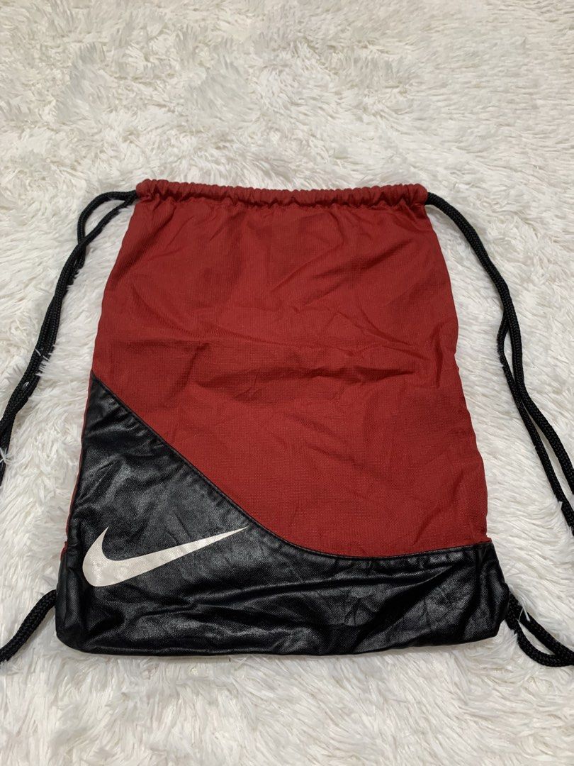 Nike Red Black Drawstring Gym Bag (Category: Backpacks) located in Iba. Submitted by thriftcoyan (Listing ID 1442874388, Image 2). Description: - Red and black Nike drawstring bag - Features the iconic Nike swoosh logo - Made of durable 100% polyester - Ideal for gym sessions or carrying everyday essentials - Convenient and easy-to-use drawstring closure - A practical and stylish choice for daily use.