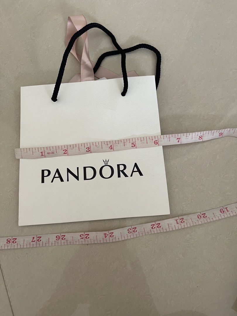 Pandora Shopping Bag (Category: Luxury Bags & Wallets) located in Taguig. Submitted by supplementary (Listing ID 1442732228, Image 2). Description: - White Pandora paper bag - Pink ribbon handles - Black rope handles also attached - Approximately 6 inches wide - Ideal for gifting or storing small items - Clean and in good shape.