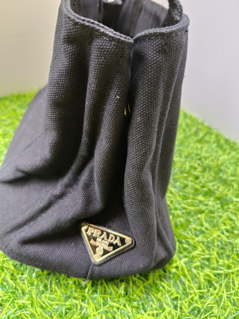 Prada Milano Black Canvas Tote Bag (Category: Luxury Bags & Wallets) located in Manila. Submitted by babylyn85 (Listing ID 1442732328, Image 2). Description: - Classic black Prada tote bag - Durable canvas material - Iconic Prada Milano logo on the front - Interior zipped pocket - Two side pockets - Sturdy and comfortable handles - Ideal for everyday use or travel.