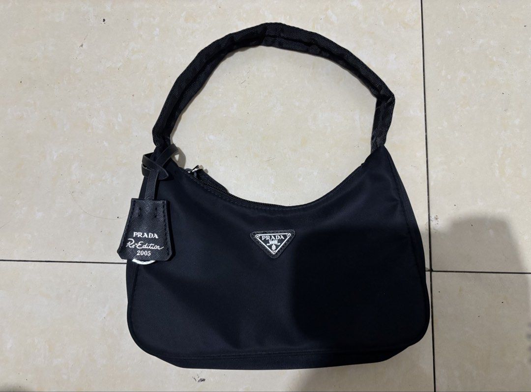 Prada Re-Edition 2003 Nylon Shoulder Bag Black (Category: Luxury Bags & Wallets) located in Manila. Submitted by van390867 (Listing ID 1442823899, Image 1). Description: Self Authenticate - Classic Prada shoulder bag - Black nylon material - Iconic triangular Prada logo on front - Leather tag: 'Re-Edition 2003' - Zipper closure - Comfortable shoulder strap - Timeless piece.