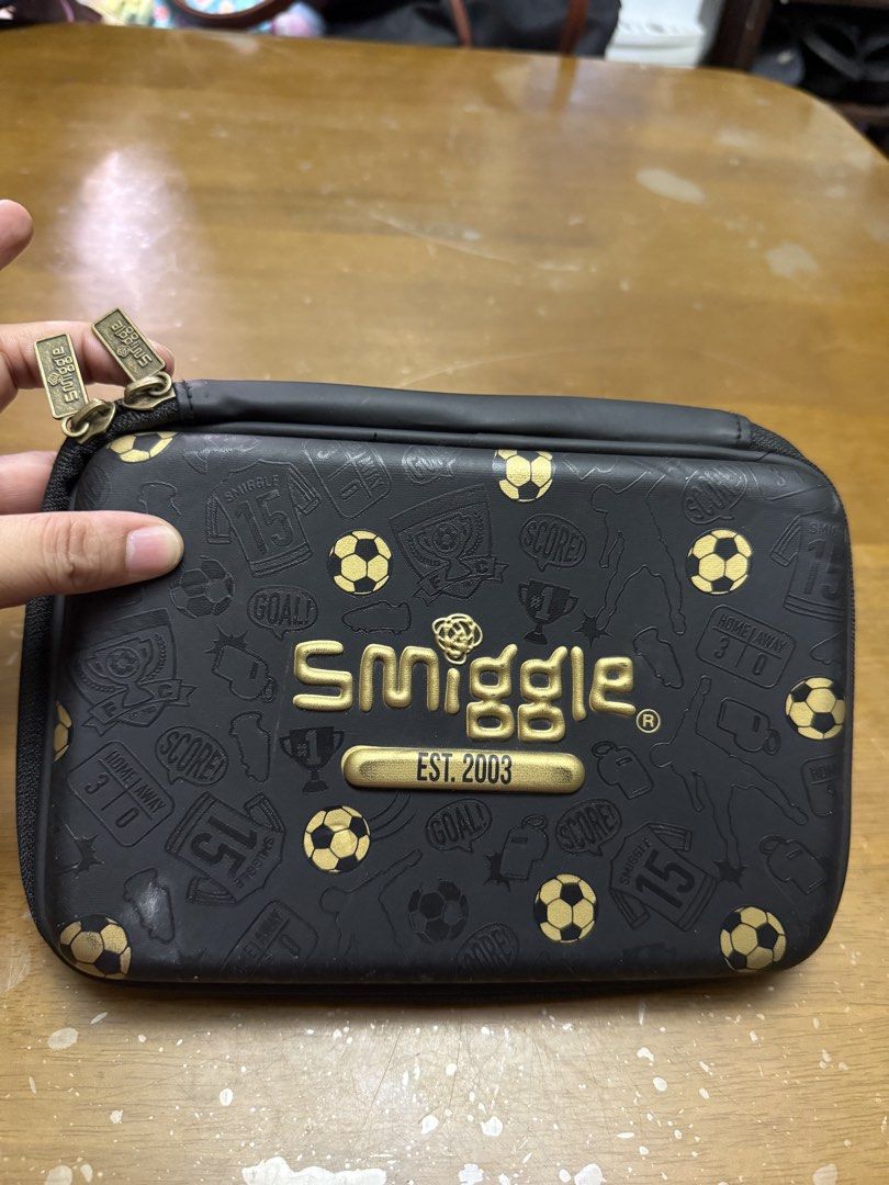 Smiggle Reversible Sequin Pencil Case - Soccer Theme (Category: Babies & Kids Fashion) located in Pilar. Submitted by faveanyshop (Listing ID 1442764359, Image 2). Description: - Smiggle pencil case with fun reversible sequins. - Flip sequins to change design: black with gold soccer ball to gold and black. - Back features a cool soccer print. - Multiple compartments for organizing stationery. - Zippers are in good working condition. - Perfect for