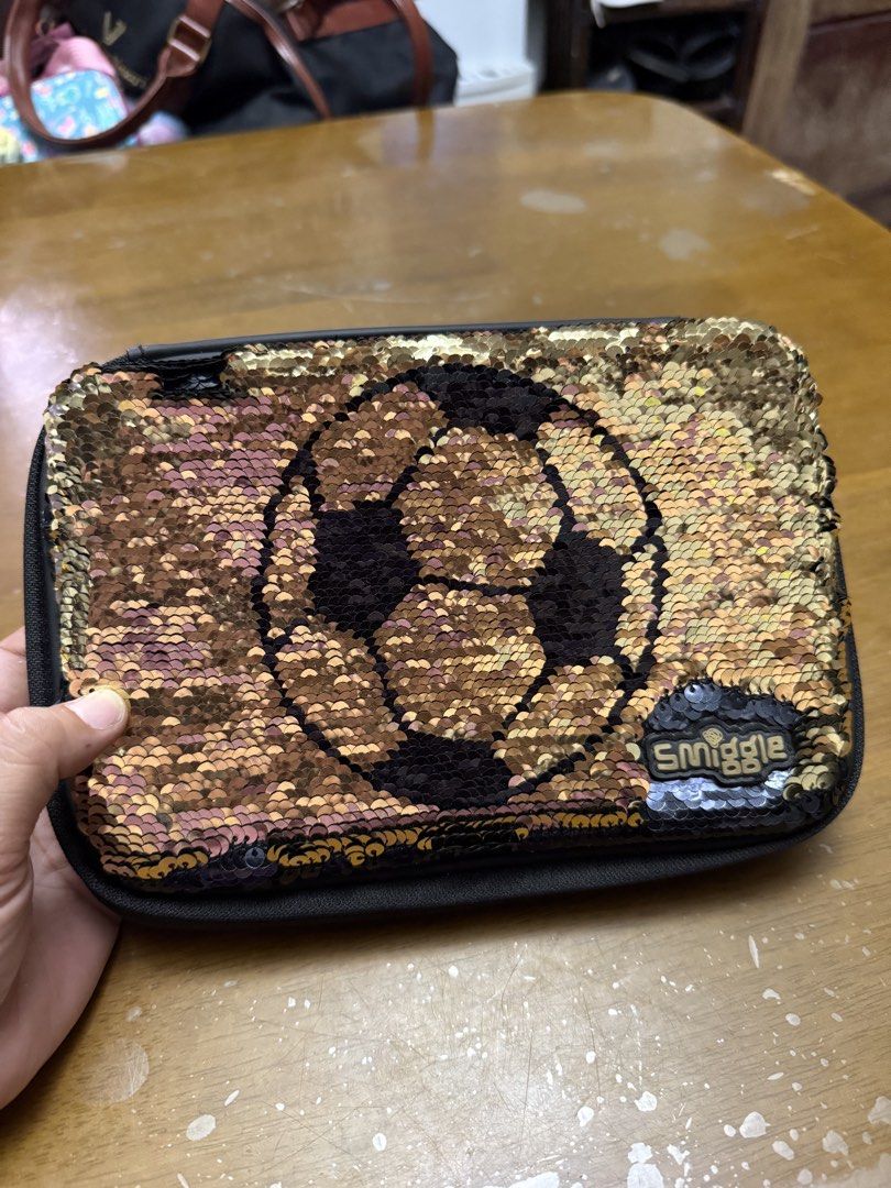 Smiggle Reversible Sequin Pencil Case - Soccer Theme (Category: Babies & Kids Fashion) located in Pilar. Submitted by faveanyshop (Listing ID 1442764359, Image 3). Description: - Smiggle pencil case with fun reversible sequins. - Flip sequins to change design: black with gold soccer ball to gold and black. - Back features a cool soccer print. - Multiple compartments for organizing stationery. - Zippers are in good working condition. - Perfect for
