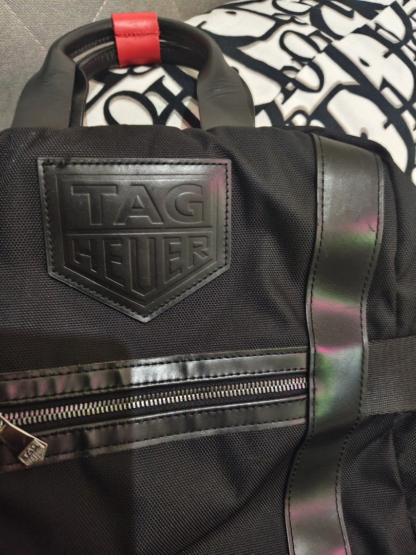 TAG HEUER Black Nylon Leather Trim Backpack (Category: Backpacks) located in Manila. Submitted by maantonett17871 (Listing ID 1442825765, Image 2). Description: - Authentic TAG HEUER backpack - Made with durable nylon and leather trim - Front zip pocket for easy access - Padded back straps for maximum comfort - Interior features TAG HEUER logo lining - Ideal for daily use, work, or travel.
