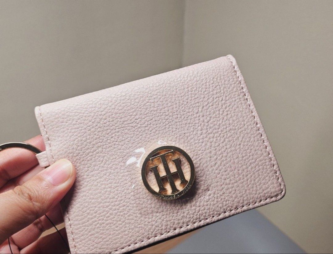Tommy Hilfiger Card Holder with Keychain (Category: Wallets & Card holders) located in Quezon City. Submitted by kleanklutter (Listing ID 1442887080, Image 1). Description: - Brand: Tommy Hilfiger Authentic!!! - Color: Light Pink - Material: Pebbled Leather - Features: Clear ID window, card slots - Additional: Gold keychain ring attached - Ideal for: Organizing essentials, small bags, pockets.