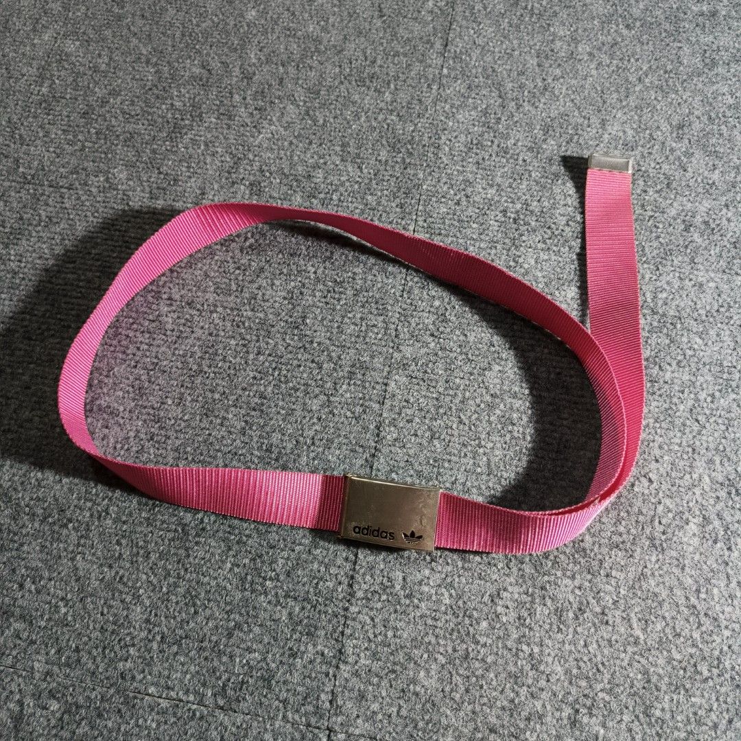 Vintage Adidas Buckle Belt (Category: Belts) located in Antipolo. Submitted by soon2byours_ (Listing ID 1442874946, Image 1). Description: - Pink Adidas belt - Features a metal buckle with the iconic Adidas logo - Durable webbing strap, perfect for everyday use - Adjustable length for a comfortable fit - Ideal for casual outfits - Shows some signs of wear on the buckle.