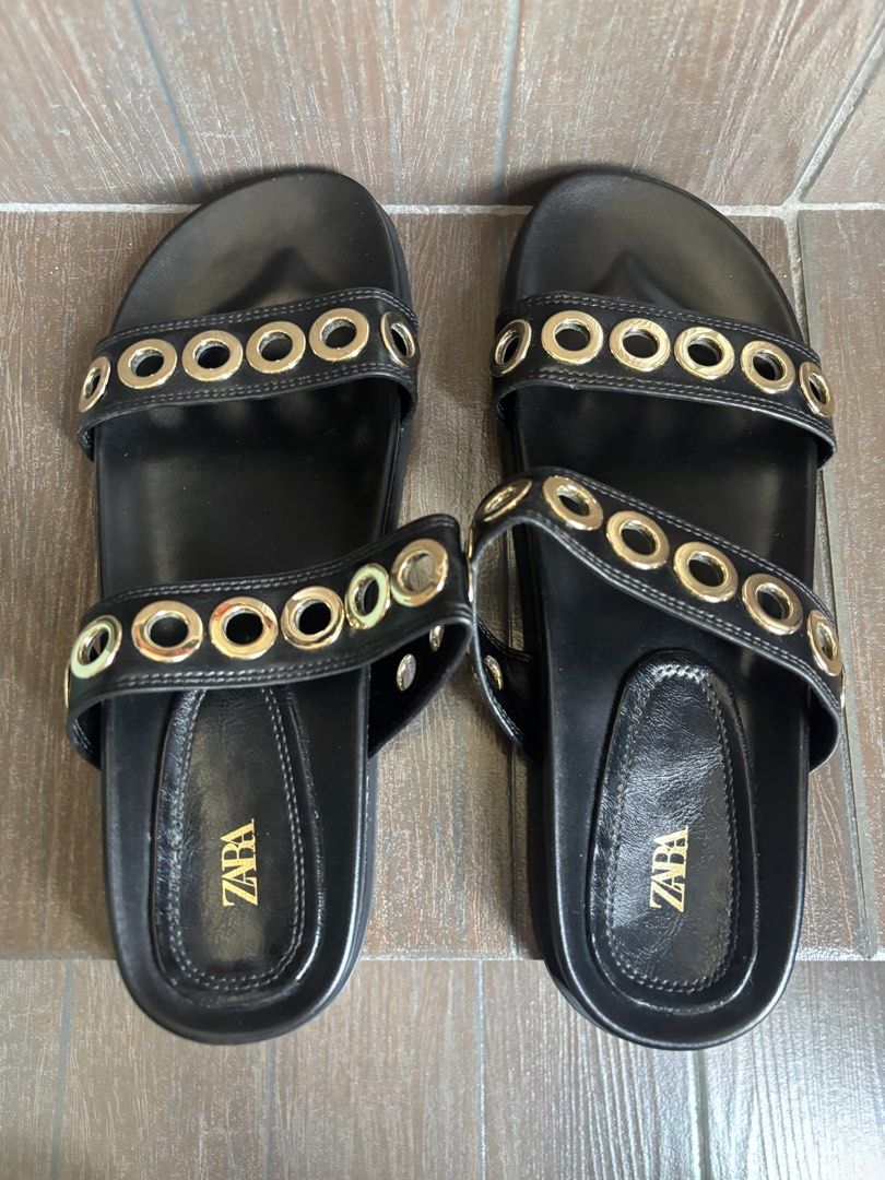 ZARA Black Leather Slides with Gold Eyelets (Category: Flats & Sandals) located in Bacoor. Submitted by mc_shopper (Listing ID 1442739575, Image 2). Description: - Zara black slide sandals - Two straps across the foot with gold-tone eyelets - Easy slip-on style - ZARA logo on insole - Ideal for casual wear - regular price 2,995.