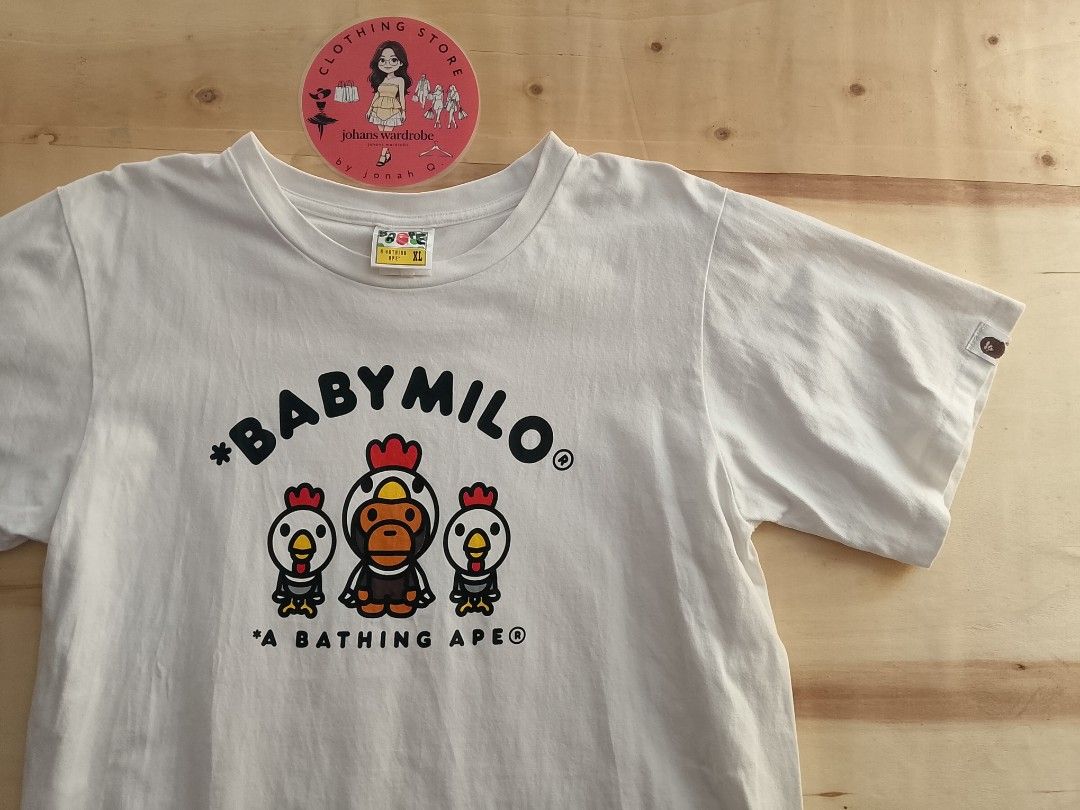 A Bathing Ape Baby Milo Chicken Graphic Tee (Category: Tshirts & Polo Shirts ) located in Manila. Submitted by jonahq.9 (Listing ID 1446975995, Image 3). Description: dimes 21x29L - White A Bathing Ape (BAPE) T-shirt - Features classic Baby Milo characters - Adorable chicken graphic - Made from 100% cotton - Ideal for everyday casual wear - Check tags for material confirmation.