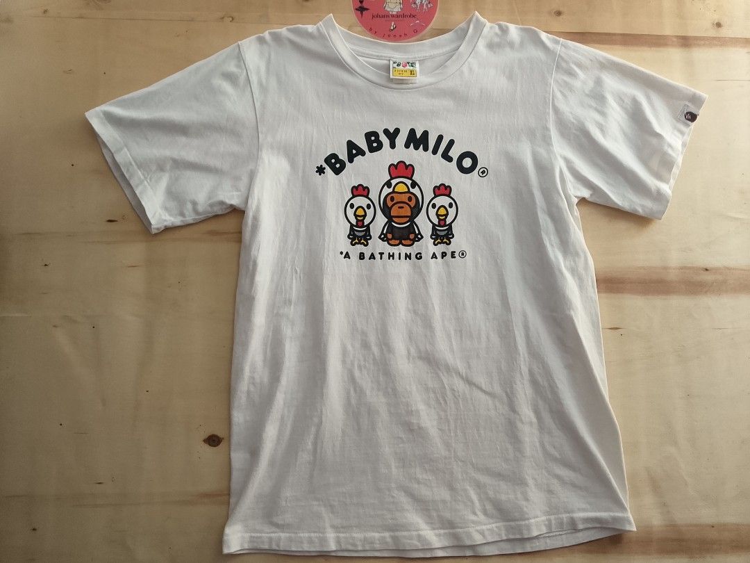 A Bathing Ape Baby Milo Chicken Graphic Tee (Category: Tshirts & Polo Shirts ) located in Manila. Submitted by jonahq.9 (Listing ID 1446975995, Image 1). Description: dimes 21x29L - White A Bathing Ape (BAPE) T-shirt - Features classic Baby Milo characters - Adorable chicken graphic - Made from 100% cotton - Ideal for everyday casual wear - Check tags for material confirmation.