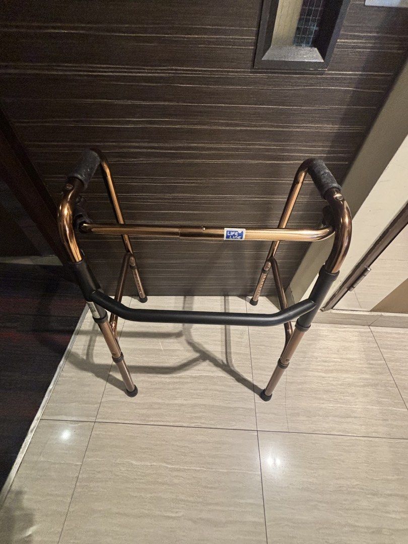 Adjustable Folding Walker (Category: Rehabilitative Devices) located in Singapore. Submitted by zblstore (Listing ID 1446965310, Image 1). Description: - Adjustable height folding walker - Bronze frame - Black handles - Folds for easy storage and transport - Ideal for mobility assistance.