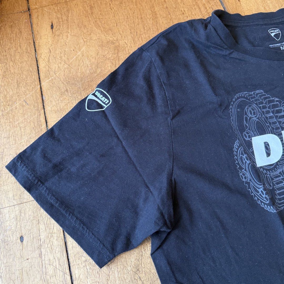 Authentic Ducati Manila Graphic T-Shirt Size M (Category: Tshirts & Polo Shirts ) located in Quezon City. Submitted by brief23 (Listing ID 1447019286, Image 3). Description: - AUTHENTIC Black Ducati T-Shirt (DISCONTINUED DESIGN) - Purchased for ₱2,300 from Ducati Manila - Size: Medium (M) - Features 'DUCATI Manila' text - Graphic print of an engine schematic on the front - Small Ducati logo detail on the left sleeve - Ideal for any Ducati fan or 
