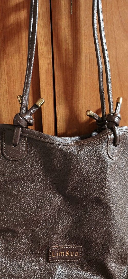 Brown Leather Tote Bag by Lim&Co (Category: Tote Bags) located in Malabon City. Submitted by ph_ohkaye (Listing ID 1446964185, Image 2). Description: - Brand: Lim&Co. - Color: Brown - Material: Textured faux leather - Features: Cute flower charm, spacious black interior - Style: Simple, classic, great for everyday use.