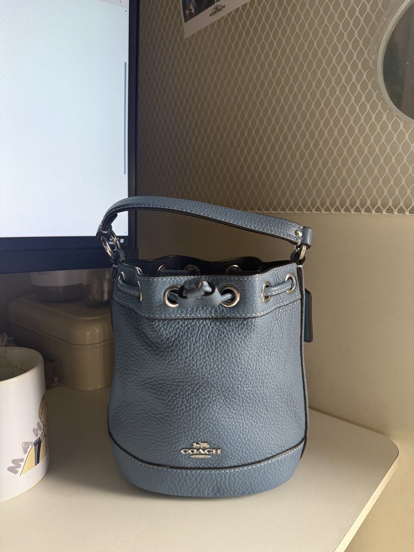 Coach - Dempsey Drawstring Bucket (Category: Luxury Bags & Wallets) located in Quezon City. Submitted by jong_17 (Listing ID 1446924145, Image 2). Description: - Authentic Coach bucket bag - Beautiful blue pebble leather, exterior in light mist with silver hardware, and a drawstring and snap closure - Top handle for hand carry - Detachable long strap for crossbody wear - Secure drawstring closure - Elegant silver hardware accents - Ideal size for