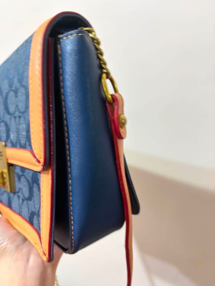 Coach Monogram Denim & Leather Shoulder Bag (Category: Luxury Bags & Wallets) located in Manila. Submitted by neri_declutters (Listing ID 1446934637, Image 2). Description: - Coach monogram denim bag - Tan leather trim - Gold chain strap - Front lock closure - Clean interior and exterior - Includes dust bag - Versatile for everyday or evening wear.