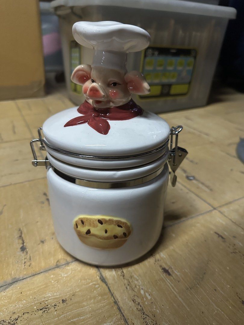 Cute Pig Chef Ceramic Cookie Jar with Clasp Lid (Category: Food Organization & Storage) located in Manila. Submitted by clamchowder19 (Listing ID 1447001374, Image 1). Description: - Adorable ceramic jar shaped like a pig chef. - Features a charming cookie design on the front. - Equipped with a secure metal clasp lid to keep contents fresh. - Ideal for storing cookies, treats, or various kitchen items. - Adds a fun and decorative touch to any kit
