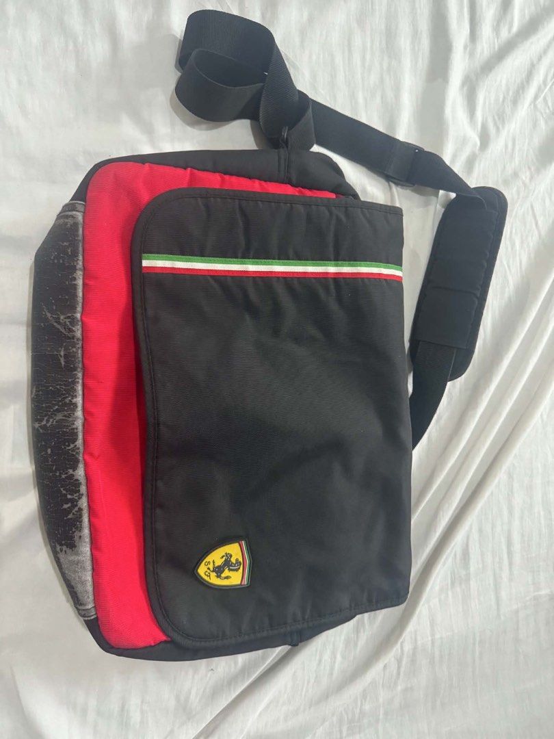 Ferrari Messenger Bag (Category: Luxury Bags & Wallets) located in Mandaluyong City. Submitted by gabbie_0708 (Listing ID 1447011528, Image 1). Description: - Iconic Ferrari shield logo, authentic - Black messenger bag with red accents - Italian flag colors on the front flap - Adjustable strap for comfortable wear - Ample interior space - Ideal for everyday use or travel Issue: faded buttom but you can replace it with leather.