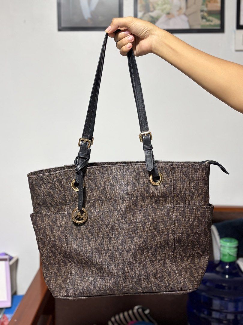 Michael Kors Monogram Tote Bag (Category: Luxury Bags & Wallets) located in Cagayan de Oro. Submitted by cruella.pipper (Listing ID 1447059149, Image 1). Description: - Classic Michael Kors tote bag - Brown monogram print - Black leather straps - Gold hardware details - Spacious interior - Two side pockets for easy access - Ideal for everyday use.