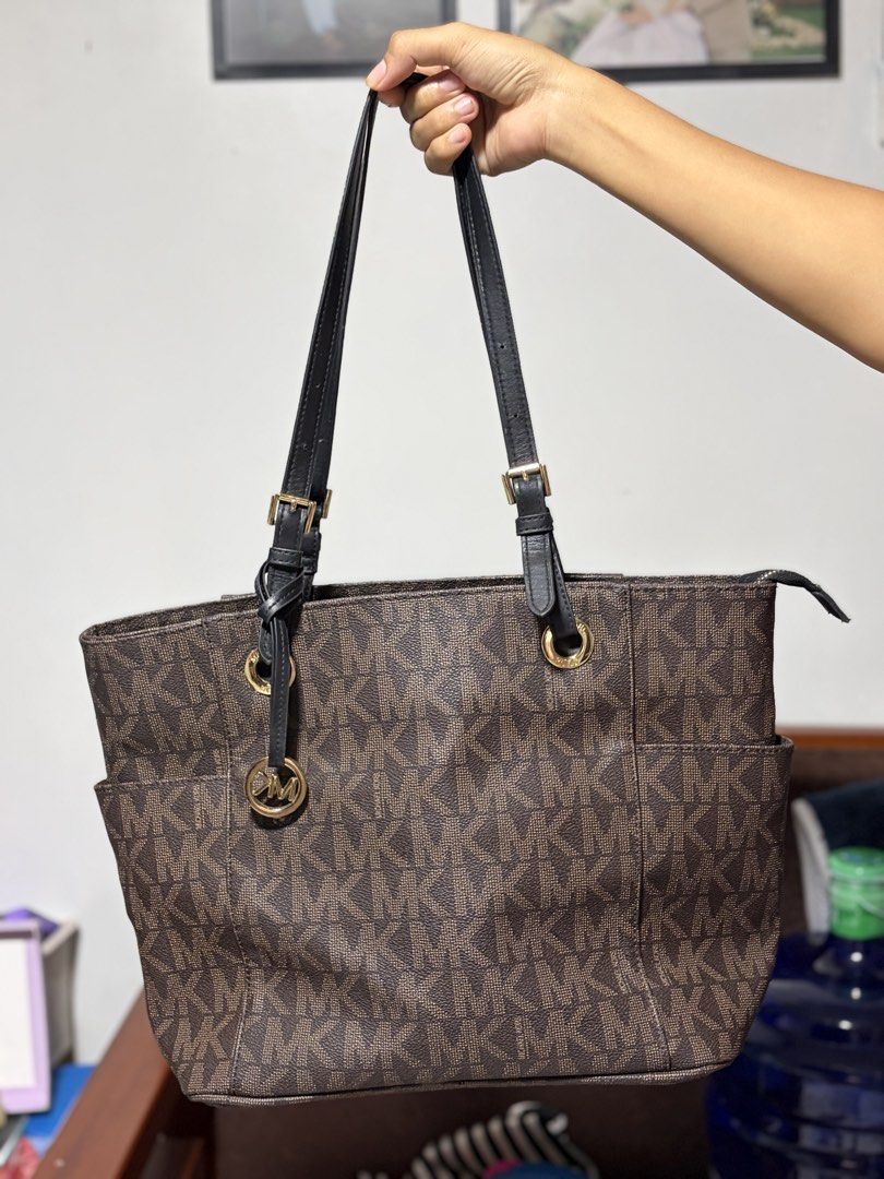 Michael Kors Monogram Tote Bag (Category: Luxury Bags & Wallets) located in Cagayan de Oro. Submitted by cruella.pipper (Listing ID 1447059149, Image 2). Description: - Classic Michael Kors tote bag - Brown monogram print - Black leather straps - Gold hardware details - Spacious interior - Two side pockets for easy access - Ideal for everyday use.