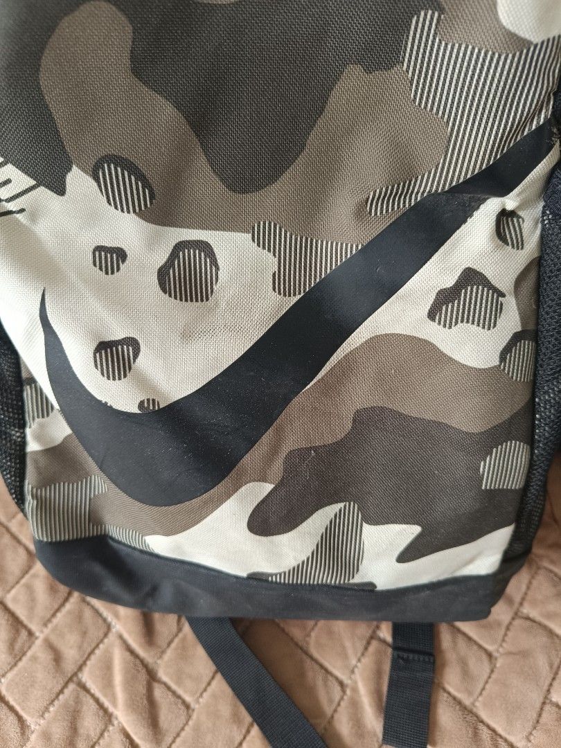 Nike Camo Backpack (Category: Backpacks) located in Marikina City. Submitted by belle0903 (Listing ID 1446958978, Image 2). Description: - Stylish Nike backpack with a cool camouflage design. - Features the iconic Nike swoosh logo. - Includes convenient side mesh pockets for water bottles or essentials. - Padded shoulder straps ensure comfortable carrying. - Ideal for school, gym sessions, or everyday adventures..