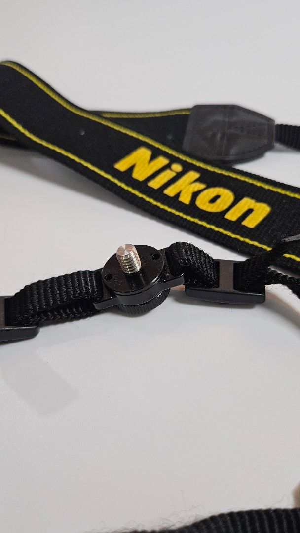 Nikon Camera Strap Black Yellow Adjustable Neck Shoulder Strap (Category: Camera Bags & Carriers) located in Alfonso. Submitted by jbcamet (Listing ID 1447029412, Image 3). Description: - Genuine Nikon camera strap - Color: Black with yellow Nikon lettering - Adjustable length for neck or shoulder wear - Features quick-release clips for easy attachment/detachment - Secure screw mount attachment - Ensures safe and comfortable carrying of your Niko