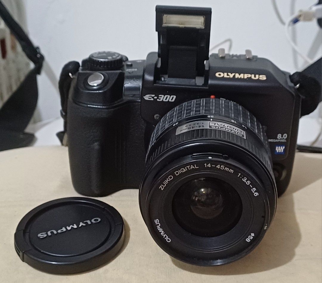 Olympus E-300 Digital SLR Camera with 14-45mm Lens (Category: Cameras) located in Quezon City. Submitted by mset.05011984 (Listing ID 1446964212, Image 2). Description: - Olympus E-300 DSLR camera - Zuiko Digital 14-45mm 1:3.5-5.6 lens included - 2GB CompactFlash card - Built-in pop-up flash - HyperCrystal LCD screen - Includes strap and lens cap - Perfect for your photography needs.