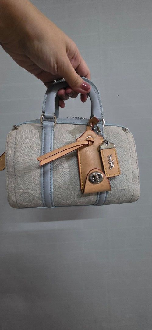 Original Coach ruby Denim Mini Barrel (Category: Luxury Bags & Wallets) located in Pasig City. Submitted by lfboutique (Listing ID 1447038921, Image 2). Description: - original and preloved Coach ruby - Signature light blue denim print - Top handles - Detachable crossbody strap - Includes leather hang tags - Ideal for carrying essentials micro size but fits big phones so cute pasig loc payment first or upon pick up .
