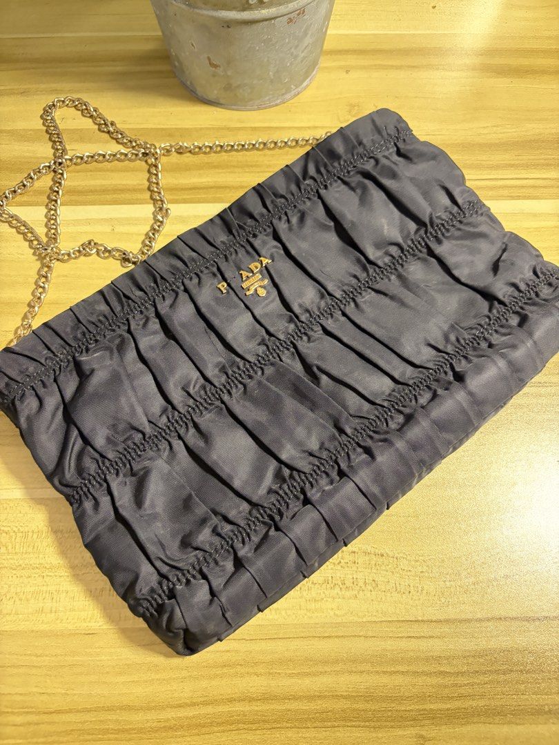 Prada Ruched Clutch Bag with Gold Chain (Category: Luxury Bags & Wallets) located in Manila. Submitted by neri_declutters (Listing ID 1447091466, Image 1). Description: - Authentic Prada clutch in dark grey - Elegant ruched fabric design - Detachable gold chain strap - Ideal for evening wear and special occasions - issue: missing R.