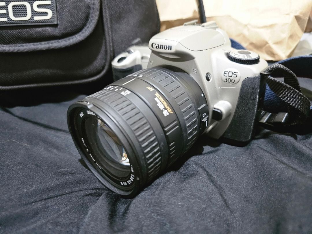 SLR CANON EOS 300 REBEL 2000 (Category: Cameras) located in Manila. Submitted by yatskiex2026 (Listing ID 1447082454, Image 1). Description: The Canon EOS 300 Lens Mount: Canon EF mount, compatible with all standard EF lenses (including modern autofocus lenses). Exposure Modes: Full Auto, Program (P), Aperture Priority (Av), Shutter Priority (Tv), Manual (M), and various scene modes. Autofocus & Metering: 7-point autofocus system and advanced mul