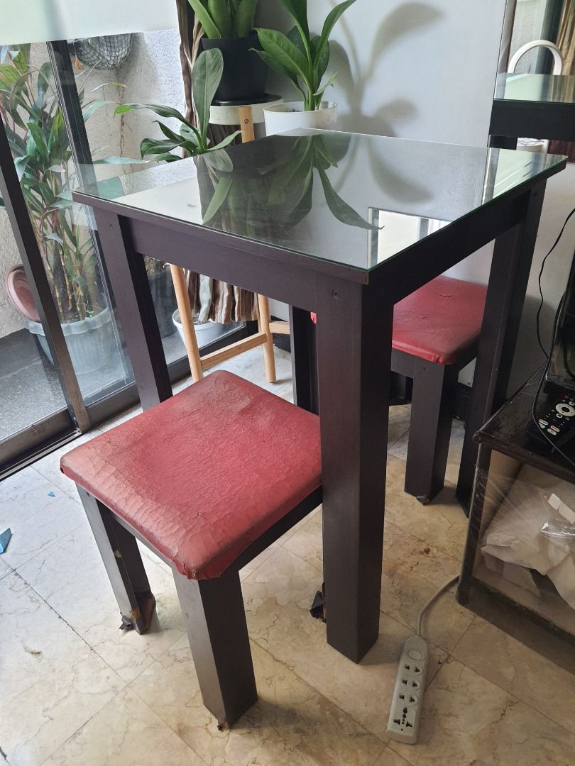 Table with glass top with 2 Red Stool Chairs (Category: Tables & Sets) located in Caloocan City. Submitted by bravemountain_ddc4bf (Listing ID 1447038877, Image 3). Description: - Clear glass tabletop - Includes 2 stool chairs - Ideal for small spaces - Note: Some wear on chair upholstery.