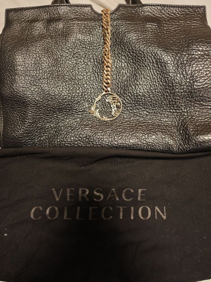Versace Black Bag (Category: Luxury Bags & Wallets) located in Quezon City. Submitted by liz11888 (Listing ID 1447068252, Image 2). Description: This is a Versace Collection black leather tote bag. Key Features Material: Textured black leather Hardware: Silver-toned metal accents Design: Dual top handles, detachable shoulder strap, and a prominent Medusa pendant hanging from a thick chain link RFS: Saving for a new bag Perfect for an everyday off